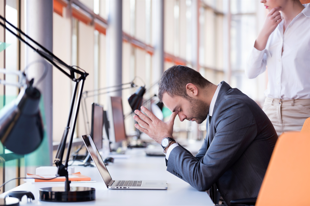 frustrated young business man working on laptop computer at office